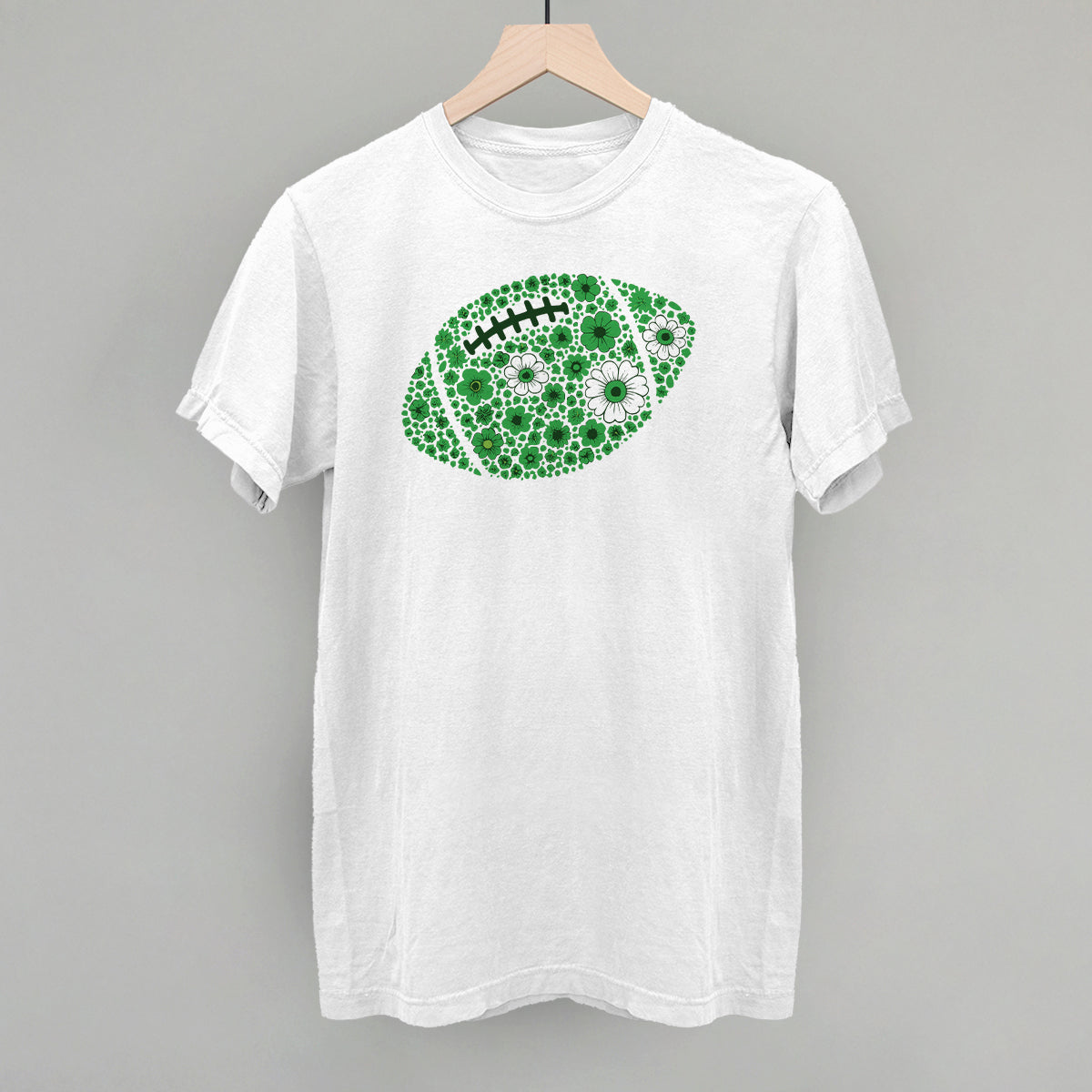 Green floral football design on a white Comfort Colors tee