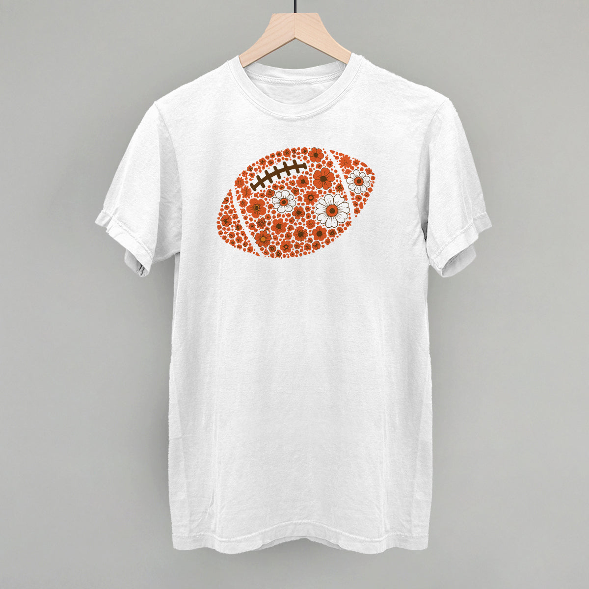 Orange floral football design on a white Comfort Colors tee