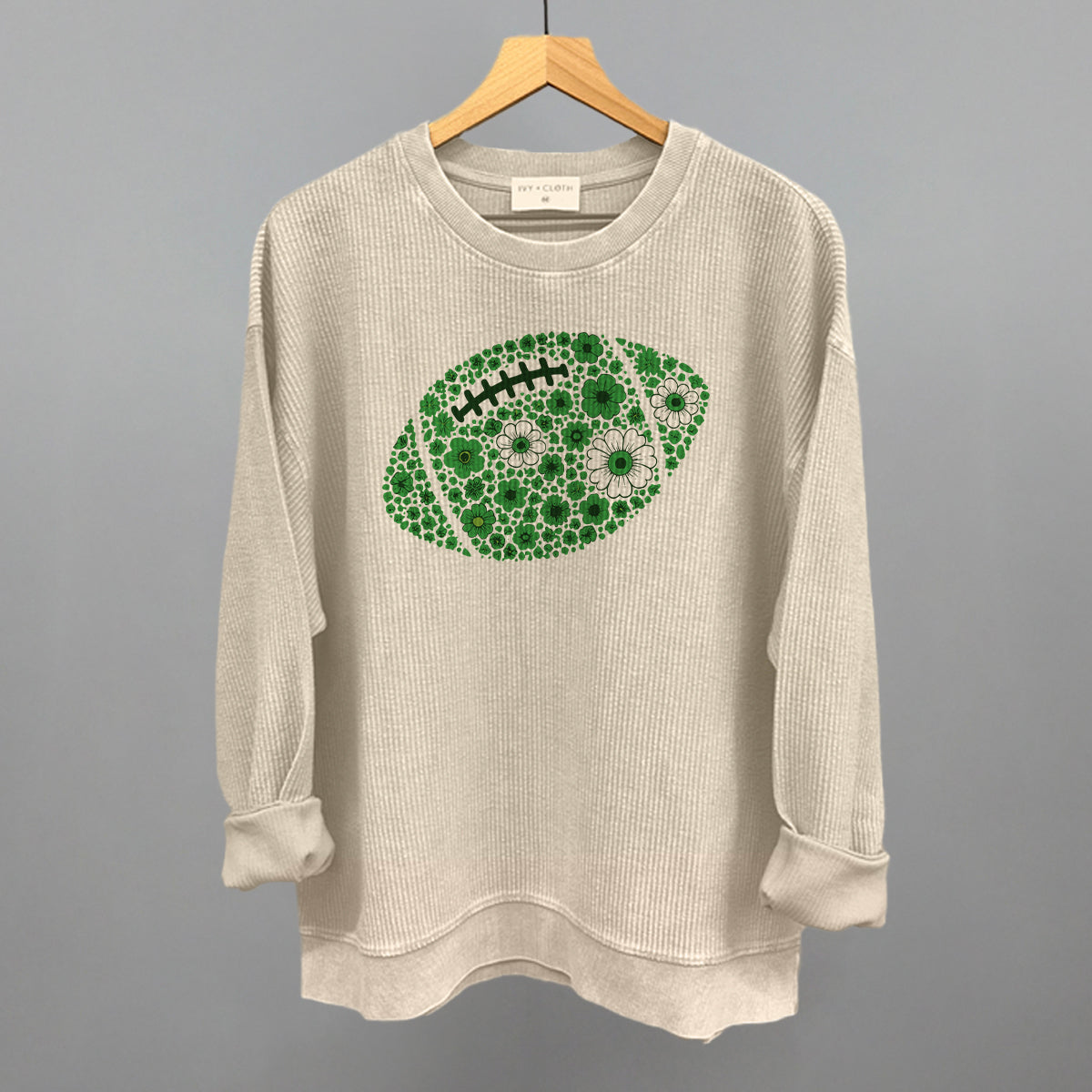Green floral football design on a moonbeam oversized corded crew