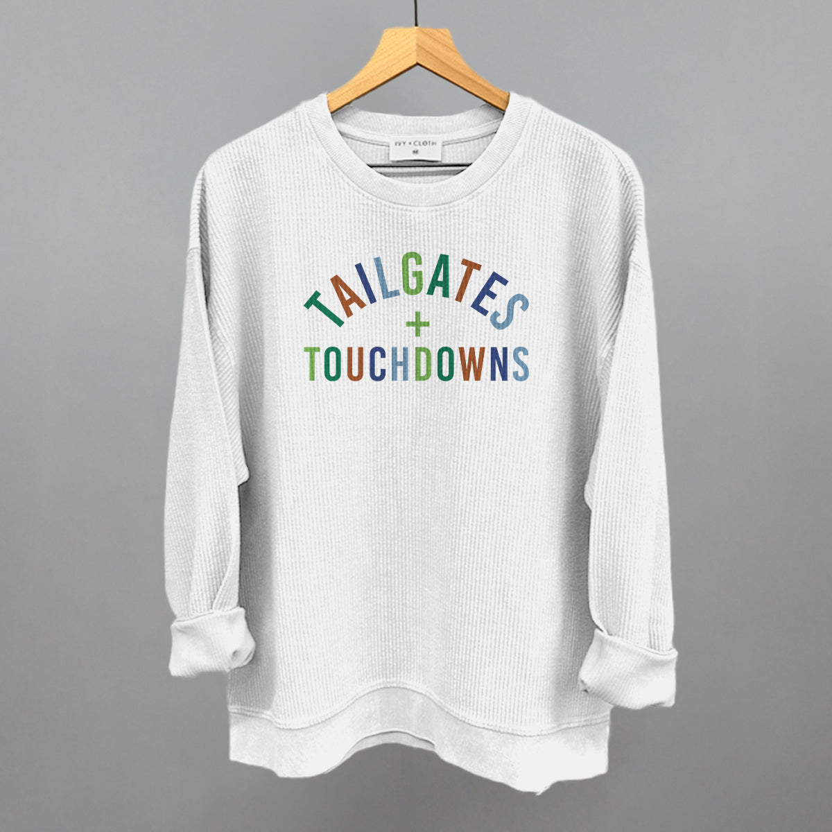 Tailgates And Touchdowns design on a white oversized corded crew