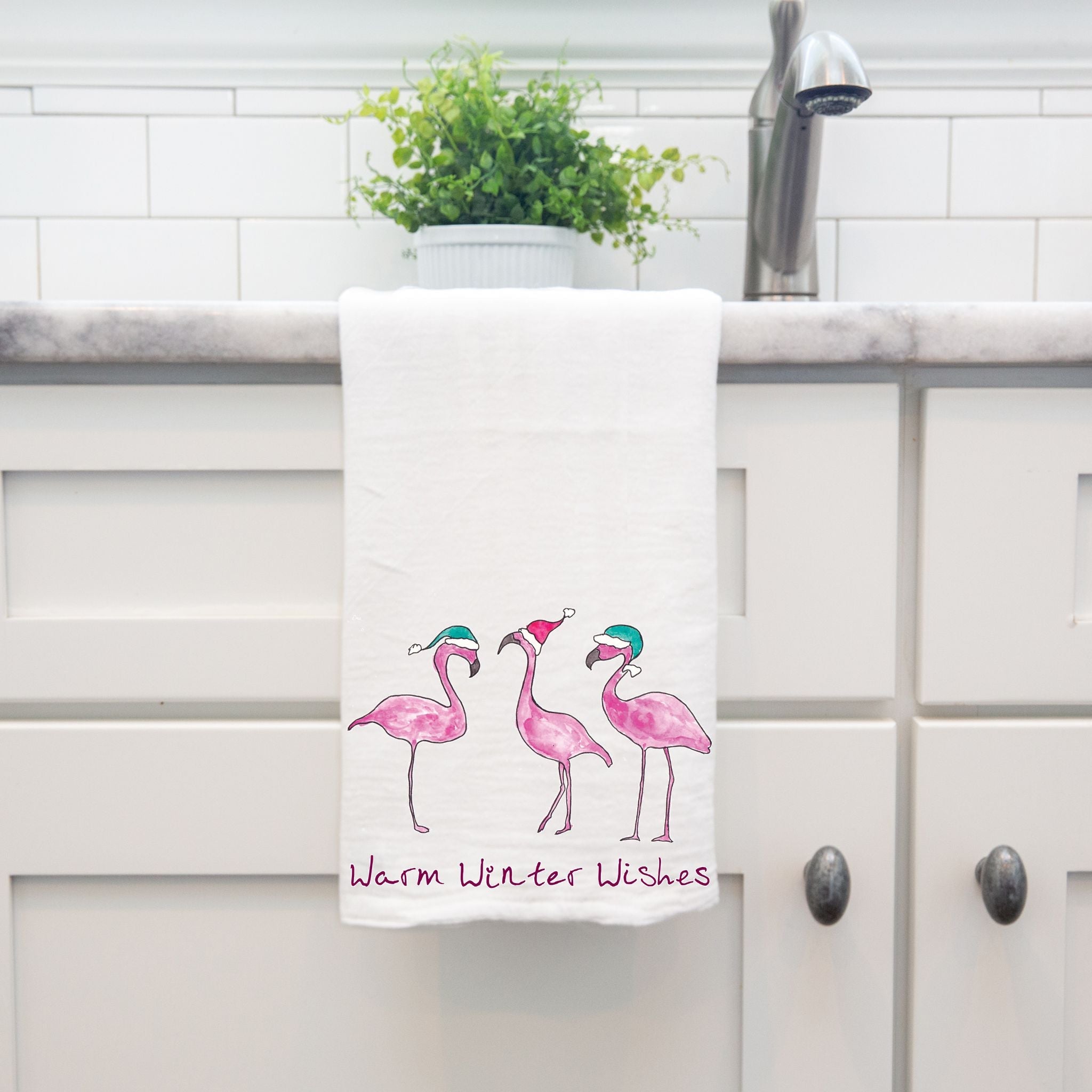 Flamingo's Warm Winter Wishes dish towel hanging by kitchen sink