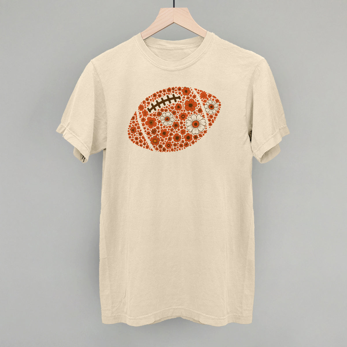 Orange floral football design on an ivory Comfort Colors tee