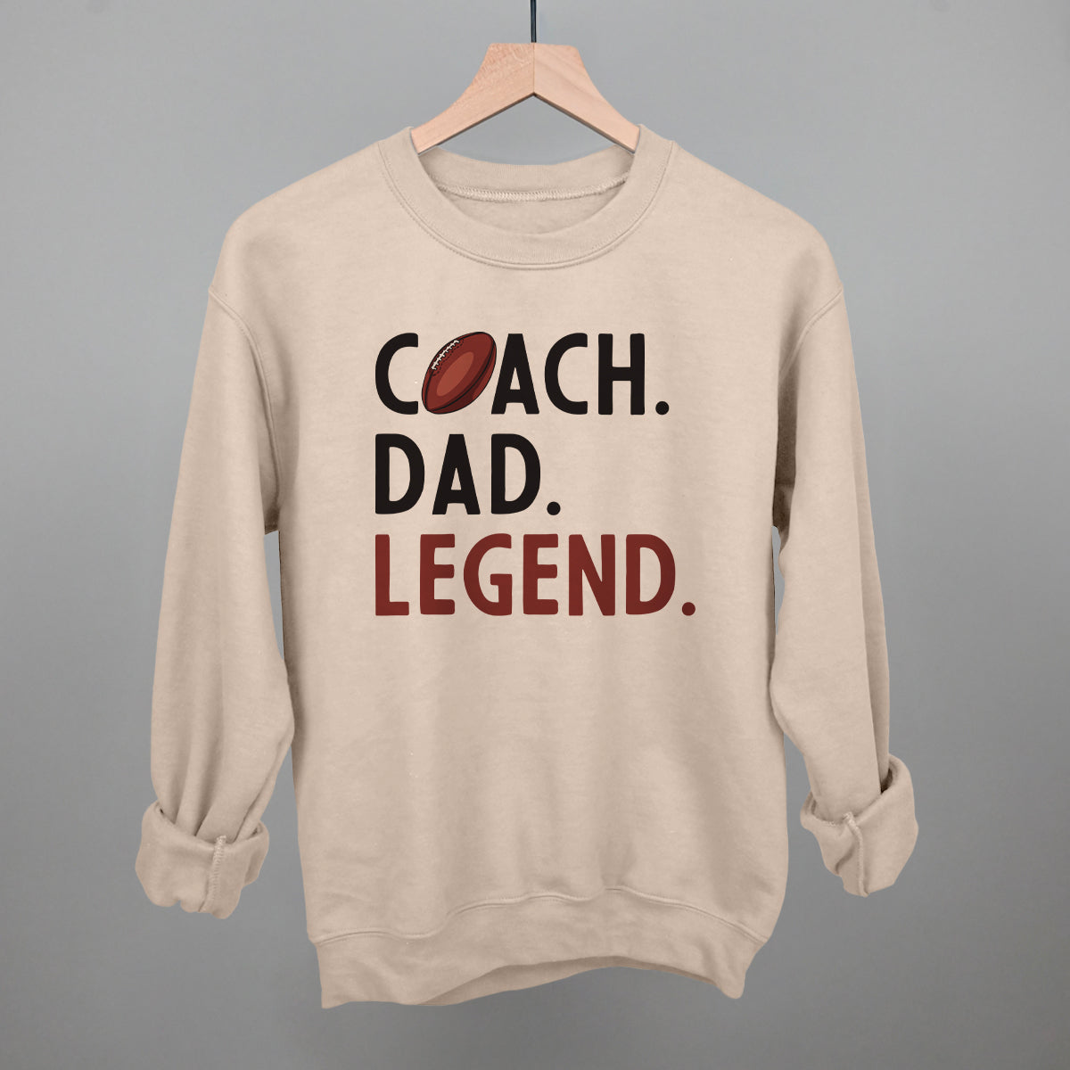 Coach Dad Legend football design on a light sandstone crewneck sweatshirt