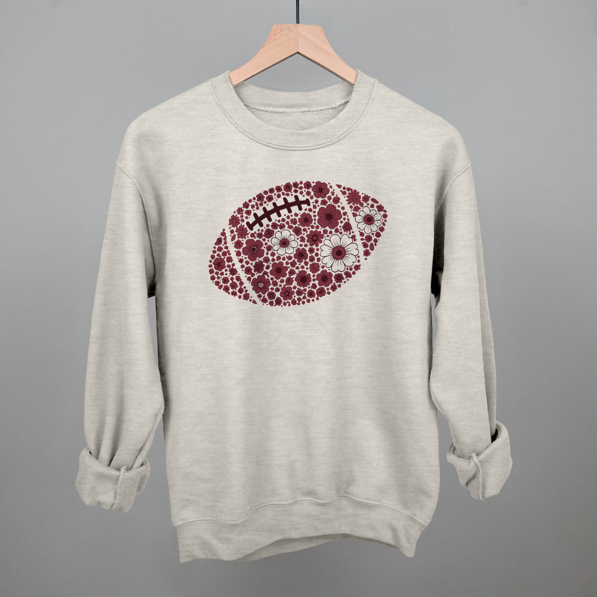 Maroon floral football design on an oatmeal crewneck sweatshirt