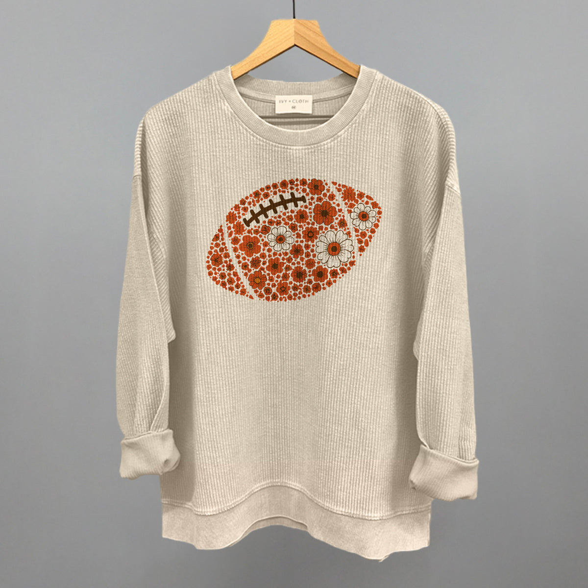 Orange floral football design on a moonbeam oversized corded crew