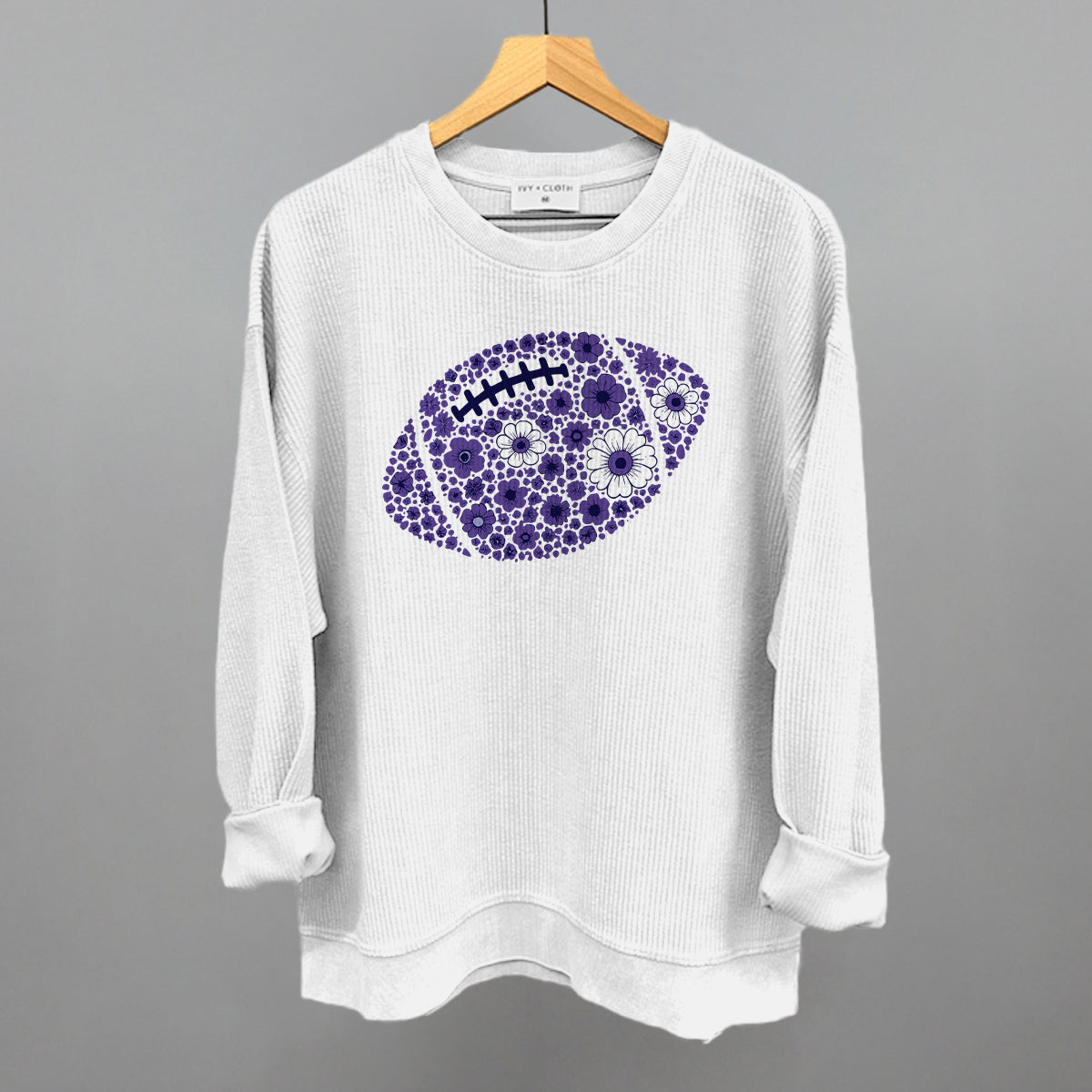 Purple floral football design on a white oversized corded crew
