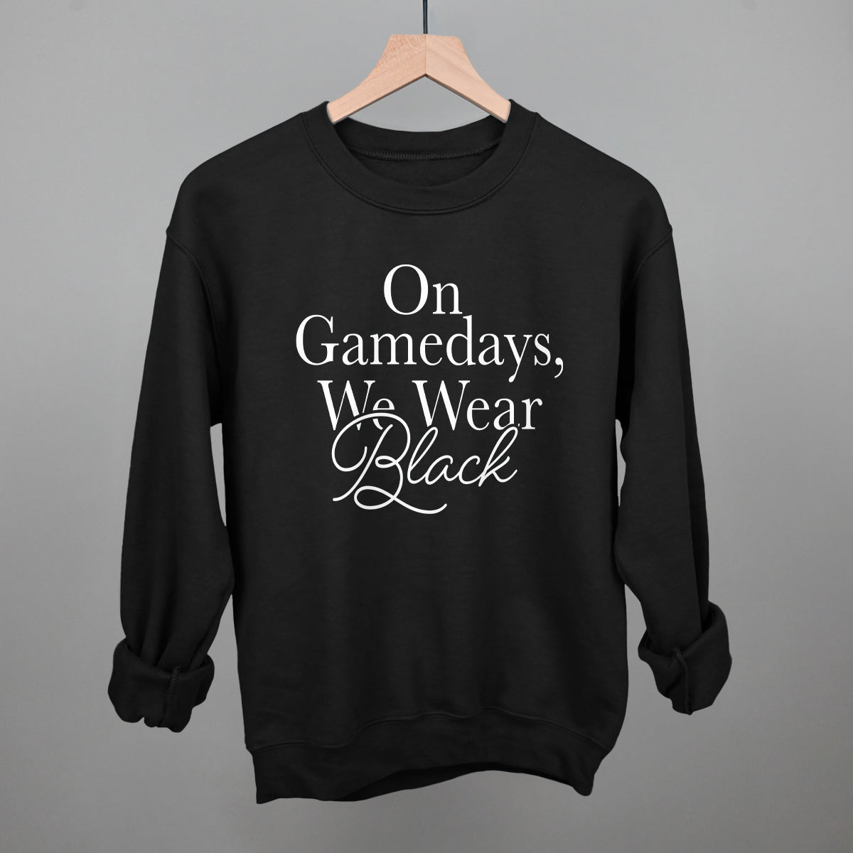 On Game Days We Wear Black design on a black fleece crewneck sweatshirt