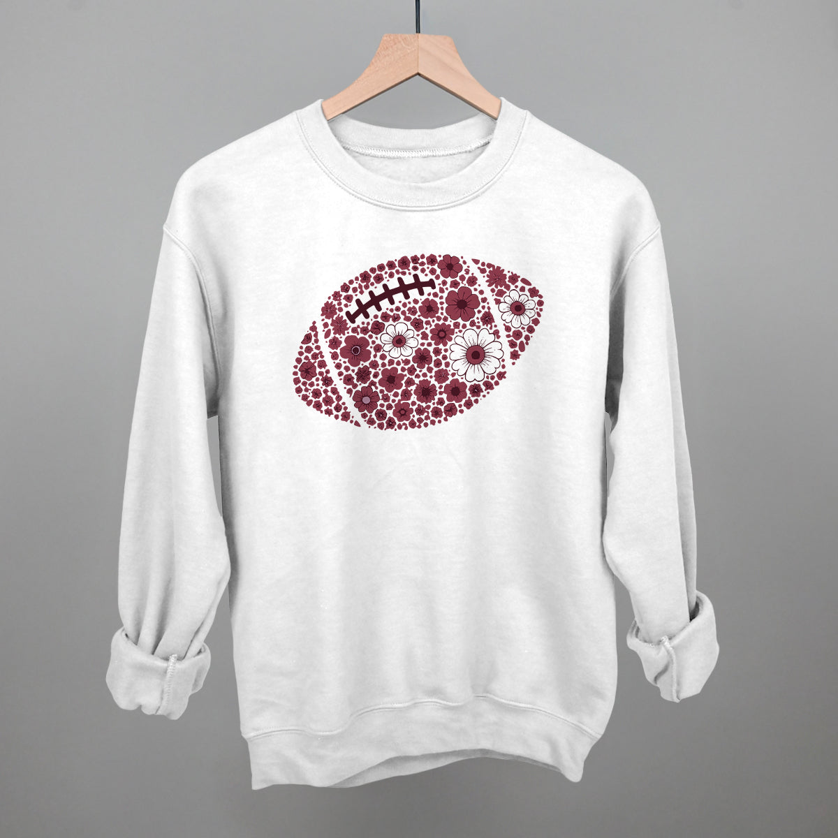 Maroon floral football design on a white fleece crewneck sweatshirt